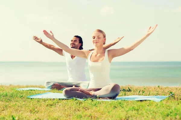 Çift gülümseyen açık havada yapım yoga egzersizleri — Stok fotoğraf