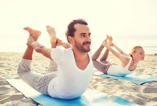 Pareja haciendo ejercicios de yoga al aire libre — Foto de Stock