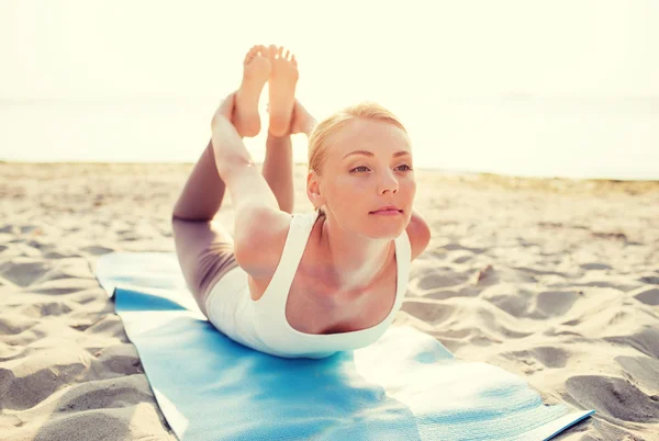 Mujer joven haciendo ejercicios de yoga al aire libre — Foto de Stock