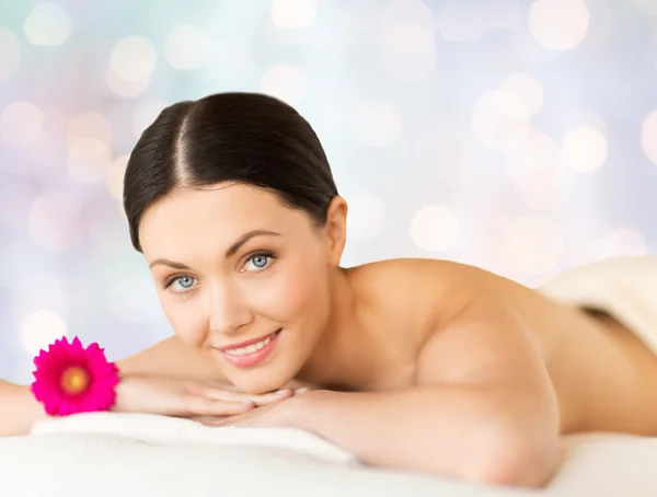 Happy beautiful woman lying on massage desk at spa — Stock Photo, Image