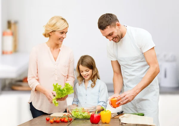 Happy family cooking vegetable salad for dinner — Stock Photo, Image
