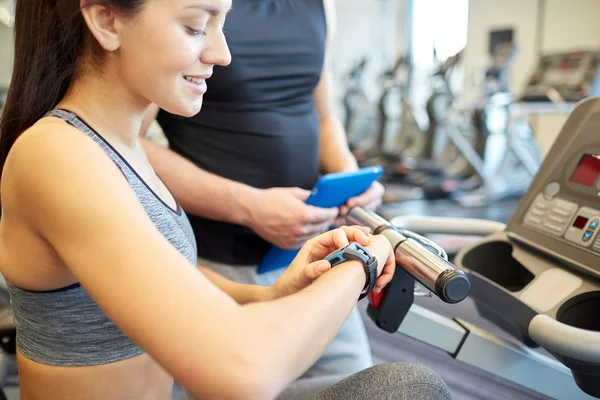 Primer plano de la mujer ajuste de frecuencia cardíaca reloj en el gimnasio — Foto de Stock