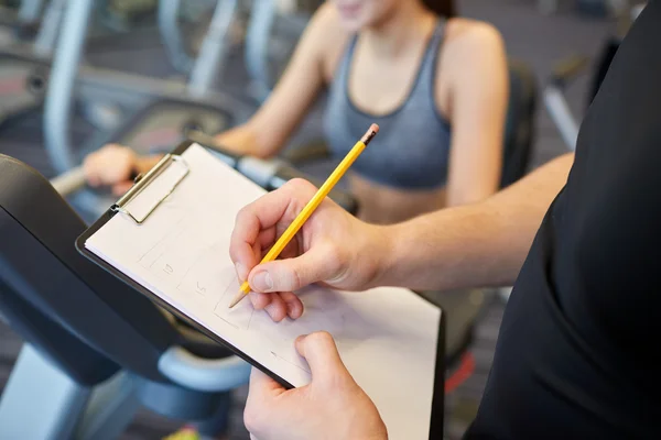 Nahaufnahme von Trainerhänden mit Klemmbrett im Fitnessstudio — Stockfoto