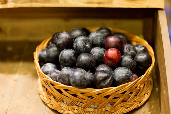 Ripe plums in basket at farm or food market — Stock Photo, Image