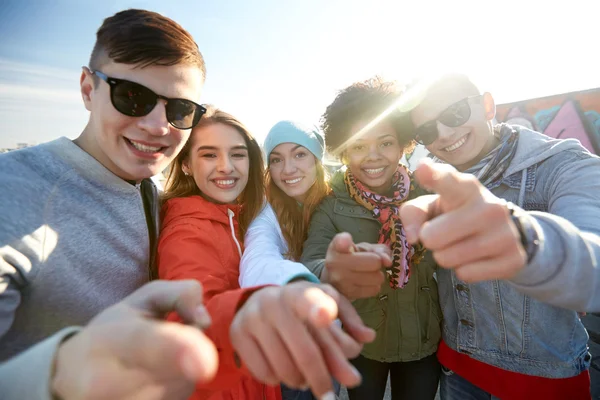 Happy teenage friends pointing fingers on street — Stock Photo, Image