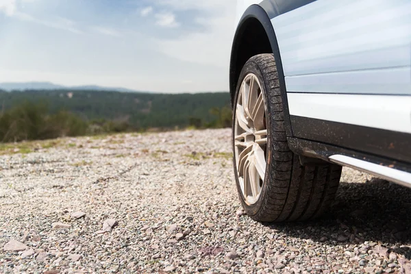 Close up of dirty car wheel on cliff — Stock Photo, Image