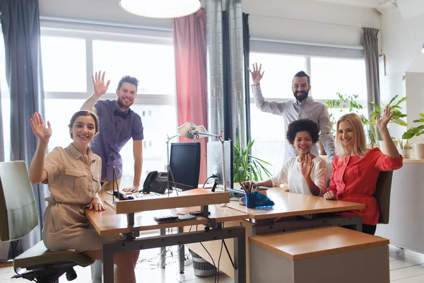 Щаслива творча команда махає руками в офісі — стокове фото