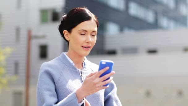 Joven mujer de negocios sonriente llamando en el teléfono inteligente — Vídeo de stock