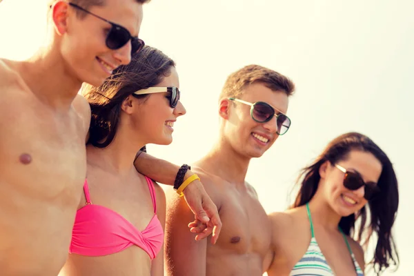Usmívající se přátelé v sluneční brýle na letní beach — Stock fotografie