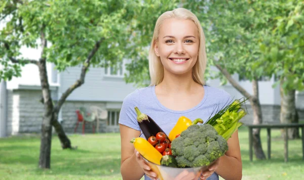 S úsměvem mladá žena se zeleninou v domácí zahradě — Stock fotografie