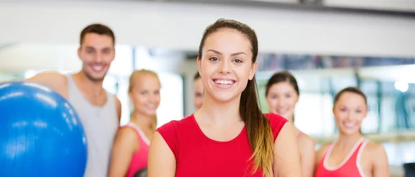 Kvinna som står framför gruppen i gym — Stockfoto