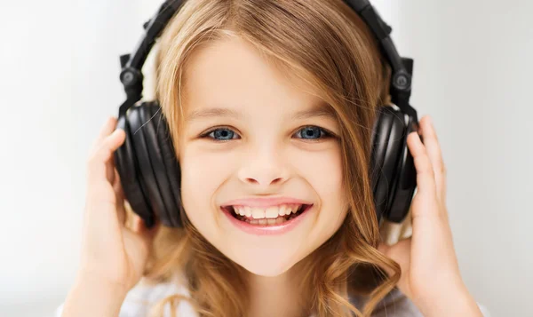 Little girl with headphones at home — Stock Photo, Image