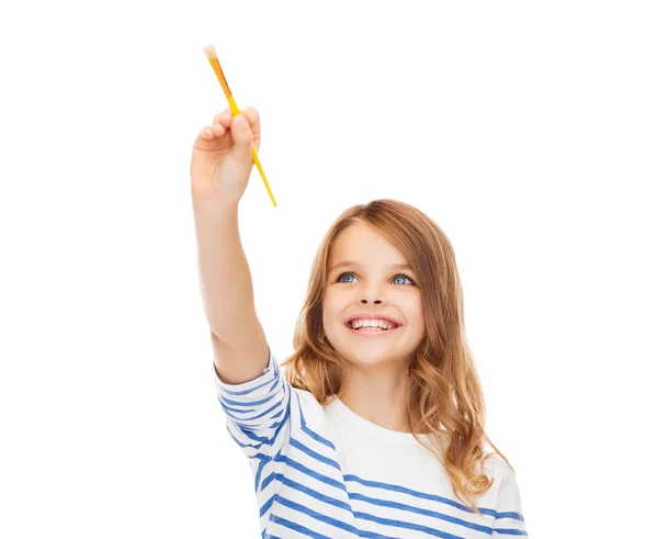 Schattig klein meisje tekenen met penseel in de lucht — Stockfoto