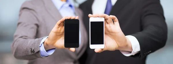 Podnikatel a obchodnice s chytrými telefony — Stock fotografie