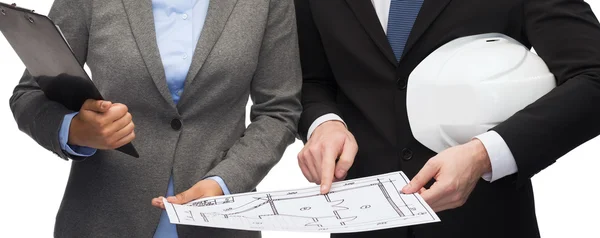 Businesspeople with blueprint and helmet — Stock Photo, Image