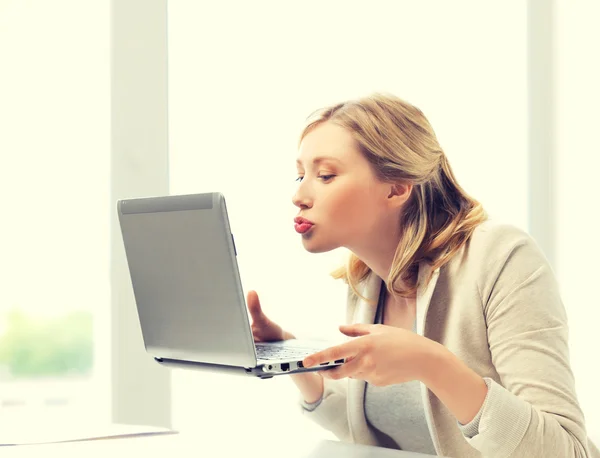Женщина отправляет поцелуи с ноутбуком — стоковое фото