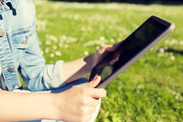 女孩坐在草地上的 tablet pc 的特写 — 图库照片