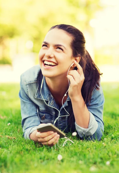 Lachen jong meisje met smartphone en koptelefoon — Stockfoto