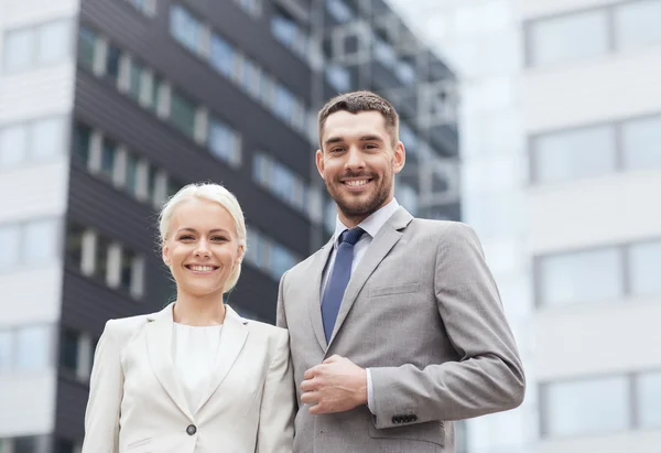 Usmívající se podnikatelé stojící nad kancelářská budova — Stock fotografie