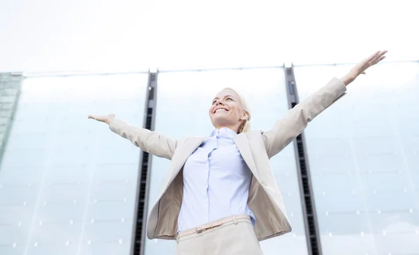 Joven mujer de negocios sonriente sobre edificio de oficinas —  Fotos de Stock