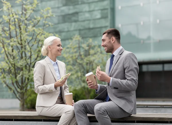 Hombres de negocios sonrientes con vasos de papel al aire libre — Foto de Stock