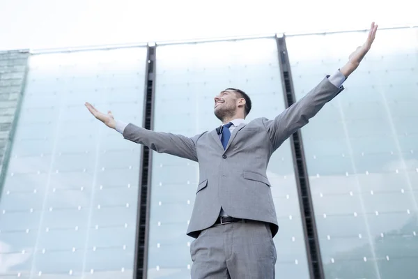 Joven hombre de negocios sonriente sobre edificio de oficinas — Foto de Stock