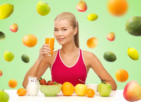 Happy woman holding glass of orange juice — Stock Photo, Image