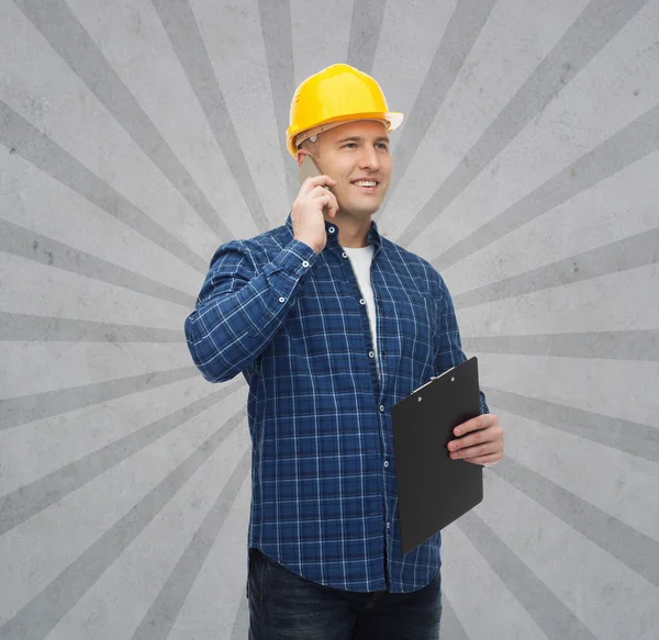 Sorridente construtor masculino no capacete com prancheta — Fotografia de Stock