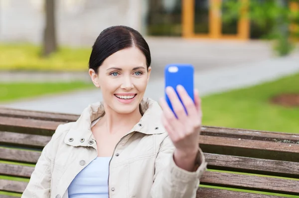 Femme souriante prenant des photos avec smartphone — Photo