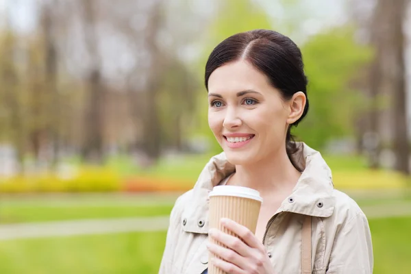 Kadın parkta içme kahve gülümseyen — Stok fotoğraf