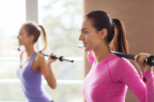 Grupo de personas haciendo ejercicio con bares en el gimnasio — Foto de Stock