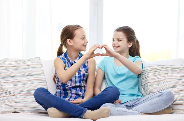 Happy little girls showing heart shape hand sign — Stock Photo, Image