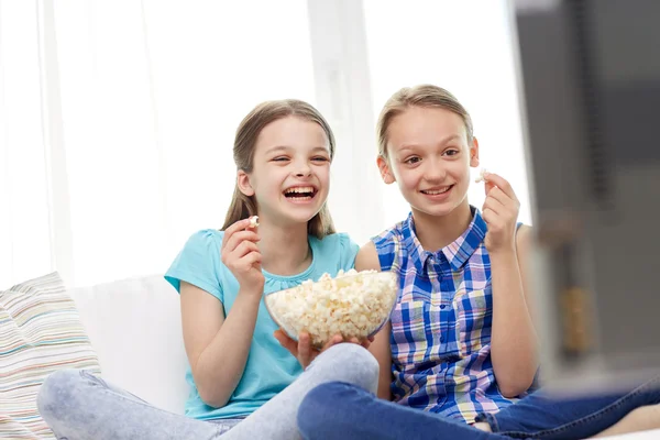 Happy girls with popcorn watching tv at home — Stock Photo, Image