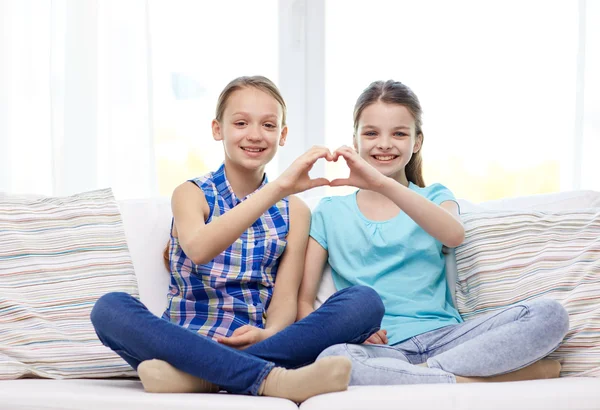 Šťastný holčičky ukazující tvar srdce rukou znamení — Stock fotografie