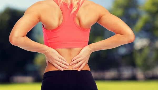 Primo piano della donna sportiva che si tocca la schiena — Foto Stock