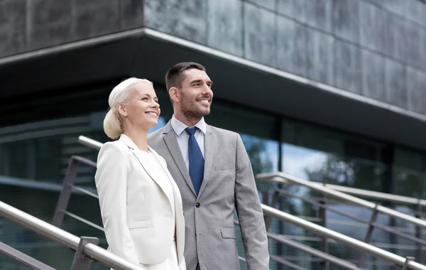 Hombres de negocios sonrientes de pie sobre el edificio de oficinas —  Fotos de Stock