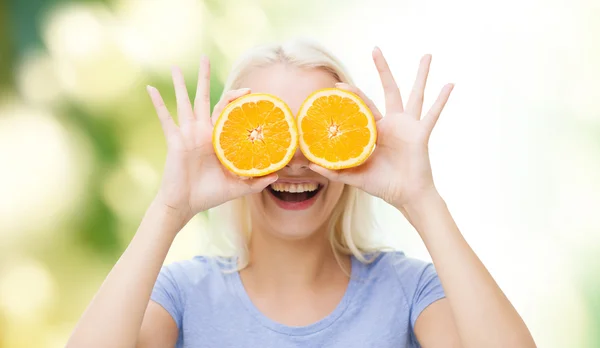 Mujer feliz que se divierte cubriendo los ojos con naranja —  Fotos de Stock