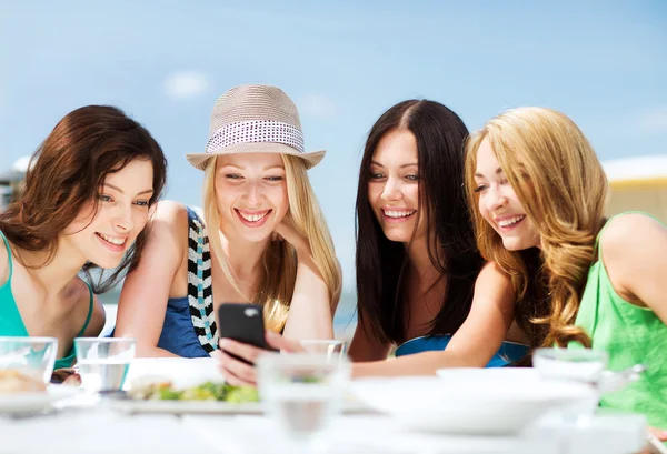 Meninas olhando para smartphone no café na praia — Fotografia de Stock