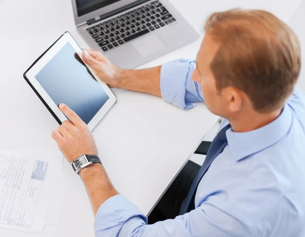 Affärsman med TabletPC och papper i office — Stockfoto