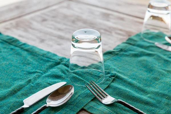 Close up of cutlery with glass and napkin on table — Stock Photo, Image