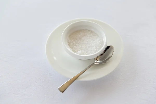 Sugar bowl and saucer with spoon on table — Stock Photo, Image