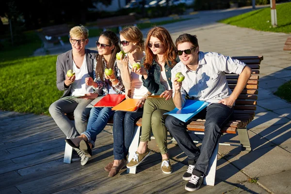 Group of happy students eating green apples — Stock Photo, Image