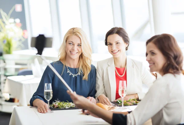 Mulheres com smartphone tirando selfie no restaurante — Fotografia de Stock