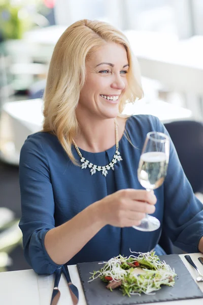 Happy woman drinking champagne at restaurant — Stock Photo, Image