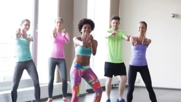 Группа улыбающихся людей, танцующих в спортзале или студии — стоковое видео