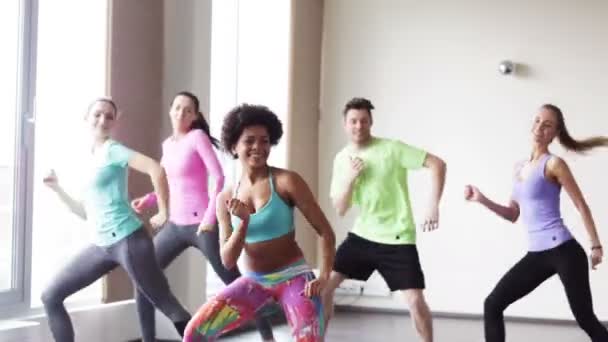 Groupe de personnes souriantes dansant en salle de gym ou studio — Video