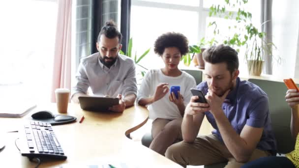 Decisão erradasquadra di affari con smartphone e tablet pcWirtschaft, Menschen, Technik und Team arbeiten Konzept - Nahaufnahme von kreativ-Team mit Smartphones und tablet-pc-Computer sitzend am Tisch im Büro — Stock video