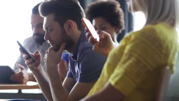 Decisão erradasquadra di affari con smartphone e tablet pcWirtschaft, Menschen, Technik und Team arbeiten Konzept - Nahaufnahme von kreativ-Team mit Smartphones und tablet-pc-Computer sitzend am Tisch im Büro — ストック動画