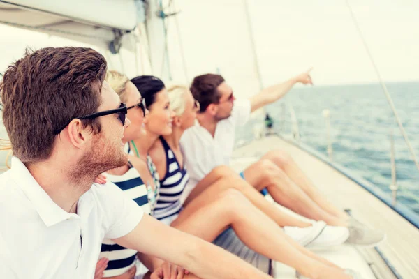 Amici sorridenti seduti sul ponte dello yacht — Foto Stock