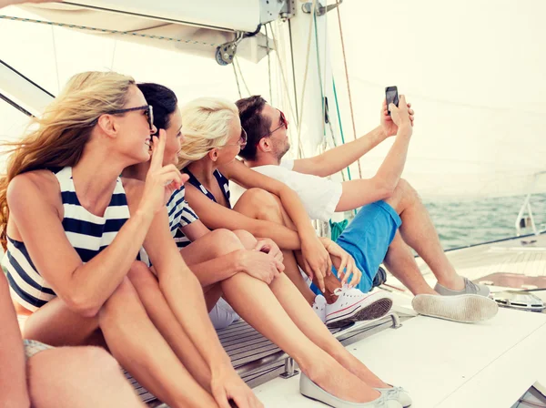 Uśmiechnięci przyjaciele siedzący na pokładzie jachtu — Zdjęcie stockowe